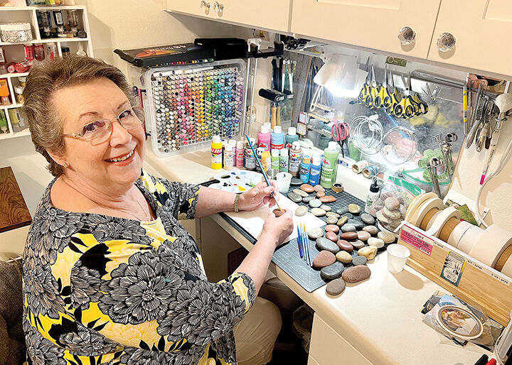 Janice Politte Mayhew puts finishing touches on painted rocks in her Pensacola home.